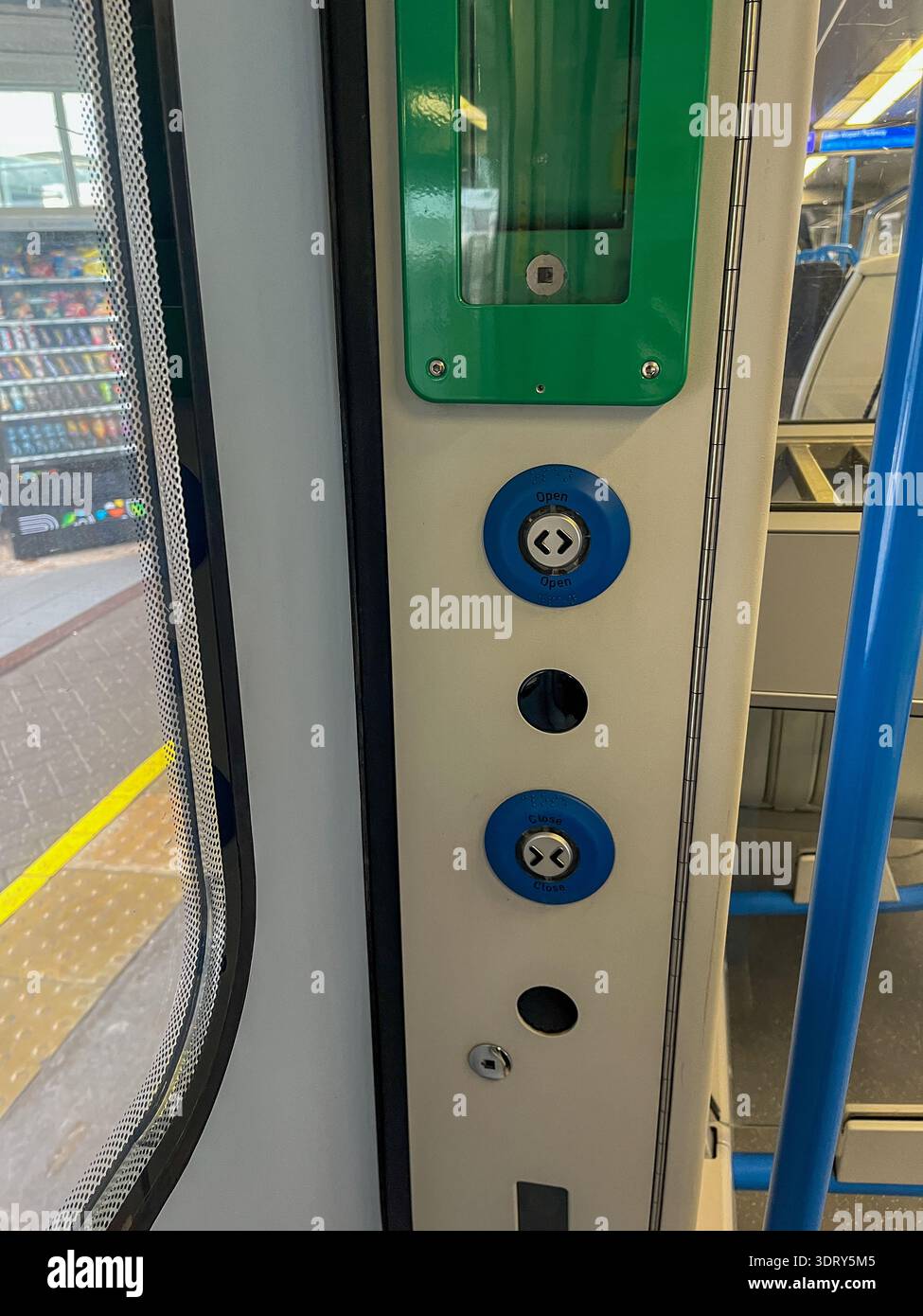 Modern train door control panel with illuminated open and close buttons in UK public transport - Smartphone Captured Stock Image