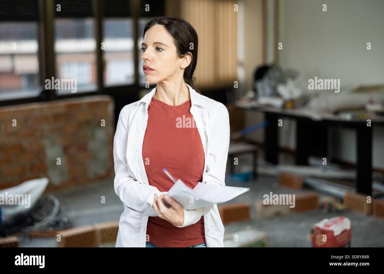 Interested brunette making notes while planning home renovation Stock Photo