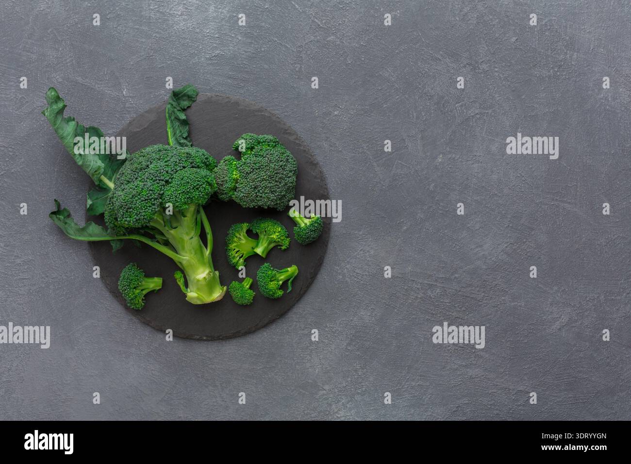 Fresh Broccoli Arranged on a Dark Surface for Healthy Cooking and Meal Preparation Stock Photo