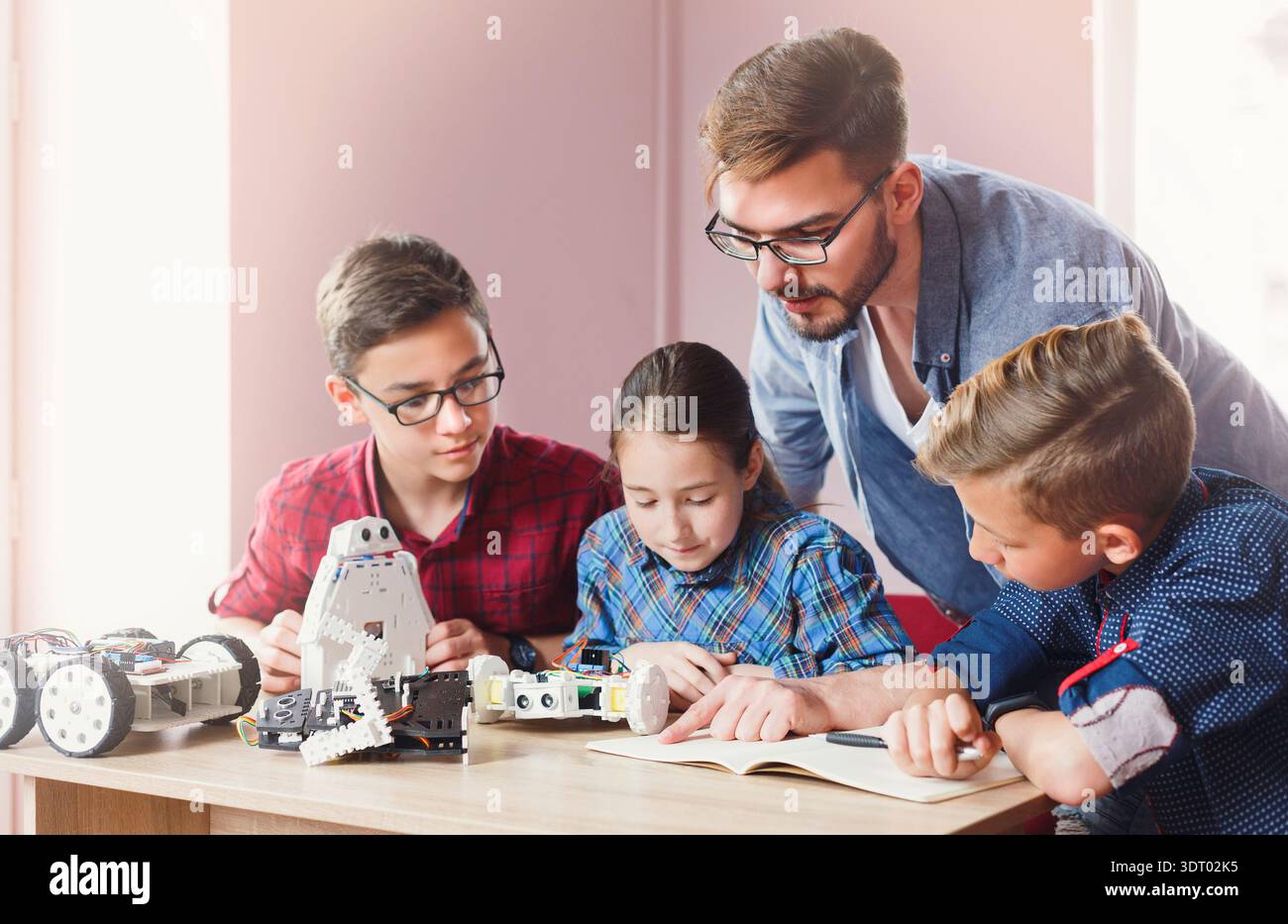 Students Learn Robotics With Guidance in Classroom During Technology Session Stock Photo