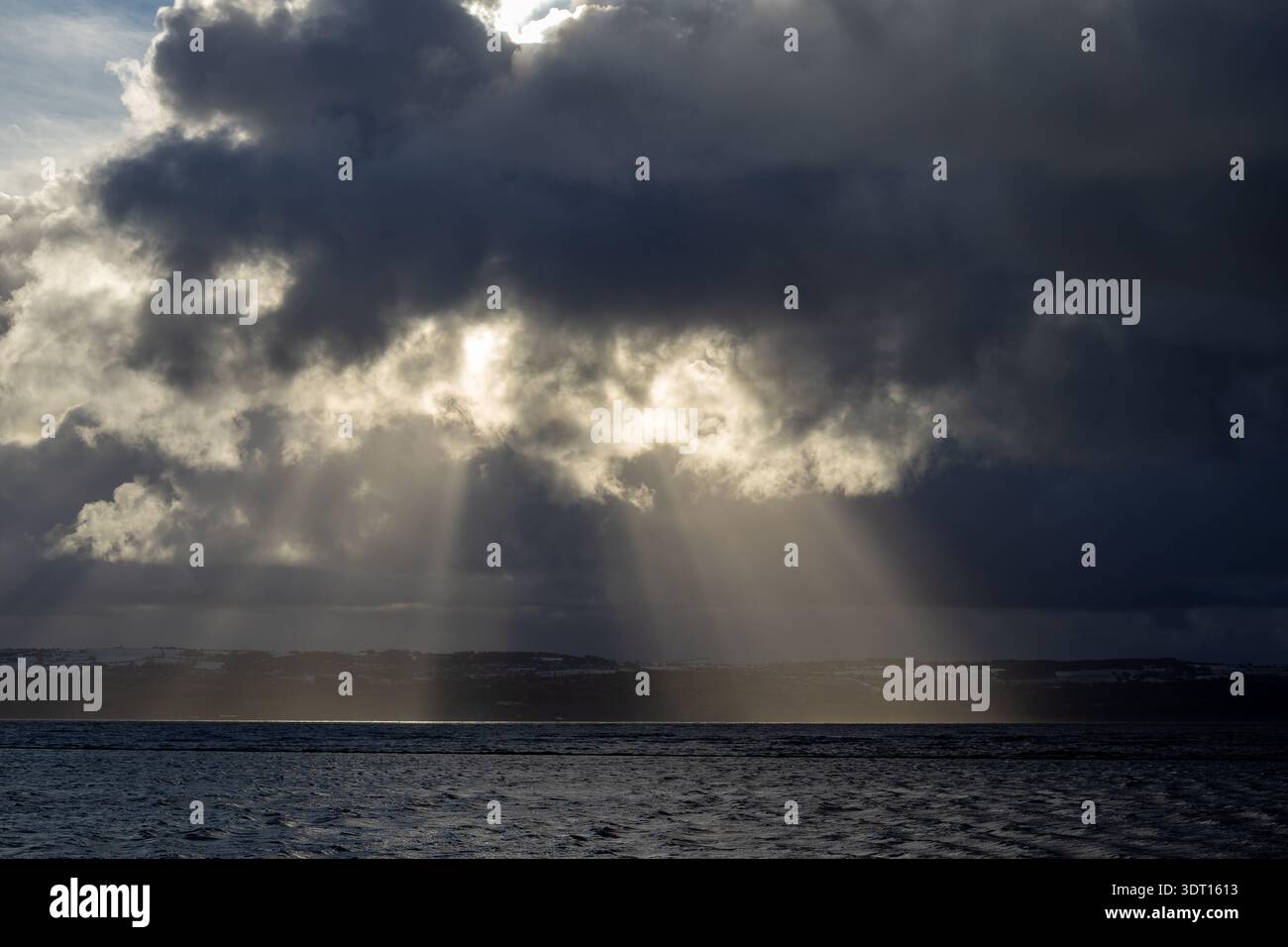 Sunbeams breaking through clouds over the Dee Estuary Stock Photo