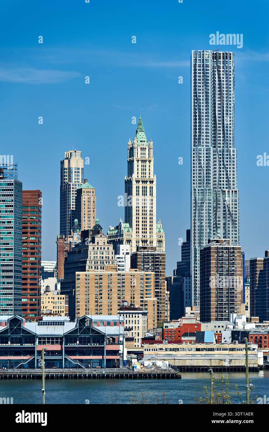 View of Manhattan skyline showing various buildings and structures on a clear day in New York City. This scene captures urban life and architecture. Stock Photo
