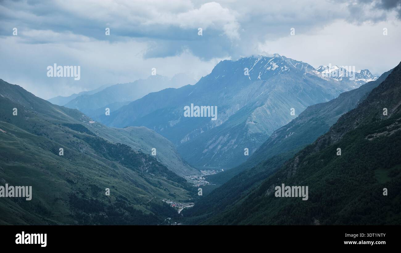Mountain Valley Landscape with Layered Ridges Under Cloudy Sky Stock Photo