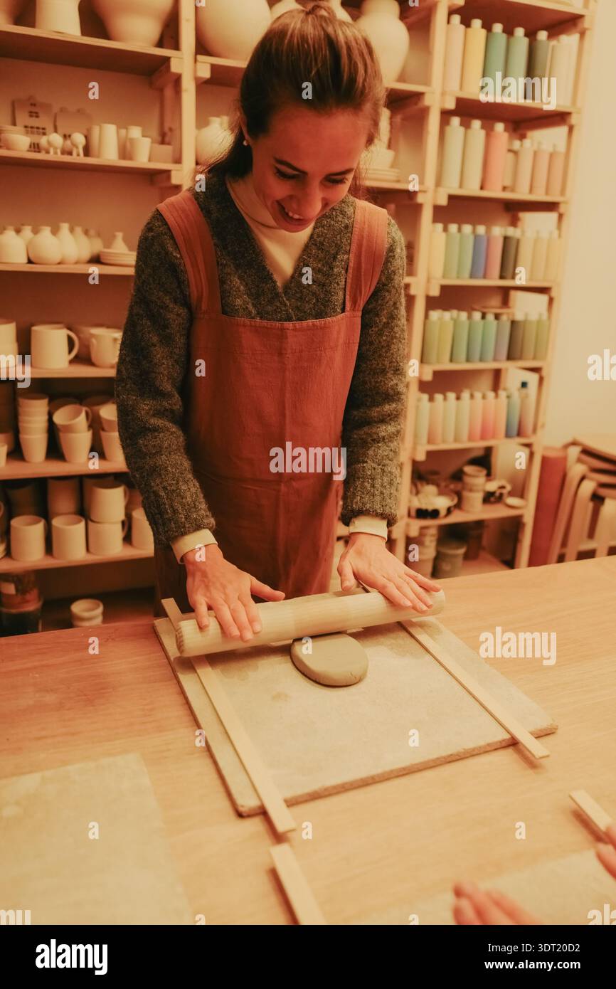 Young woman sculpting clay in pottery workshop Stock Photo