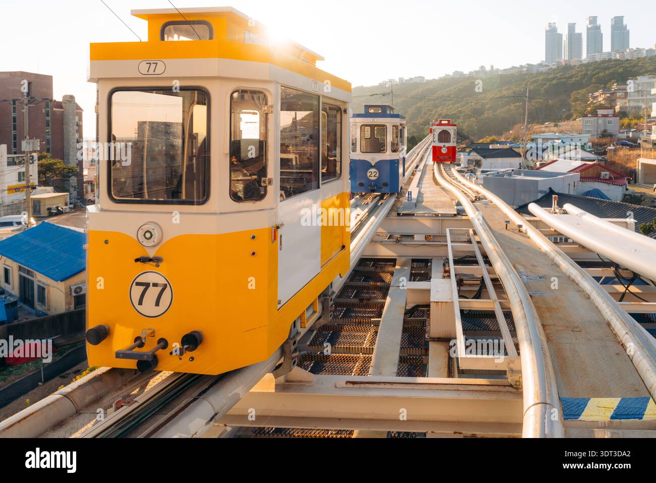 Busan monorail cars climb a hillside track, providing scenic city transport Stock Photo