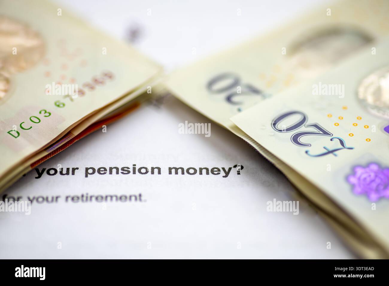 A macro close up of stacks of Pound Sterling bank notes on top of a pension planning letter. Stock Photo