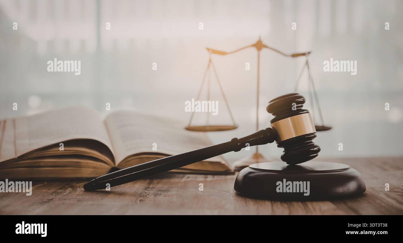 A gavel and scales of justice on a desk with an open book, symbolizing ...