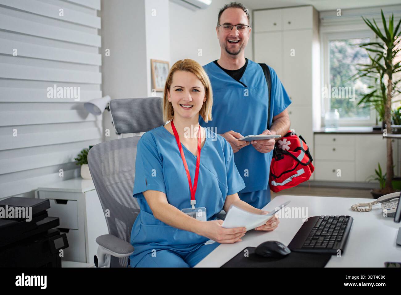 Healthcare professionals working in office smiling at camera Stock Photo