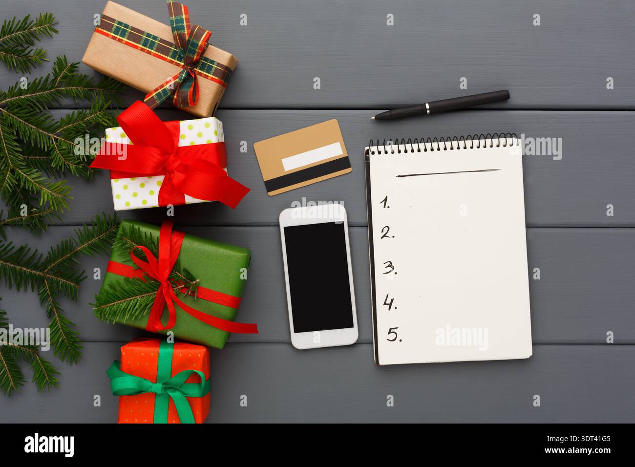 Gift Planning Time With Presents and a Notepad on a Wooden Surface Stock Photo