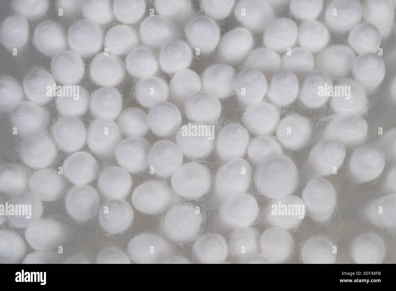 Close up cotton swabs used for cleaning electronics, dense cotton tips shown against mesh background, evokes precision maintenance and delicate dust r Stock Photo