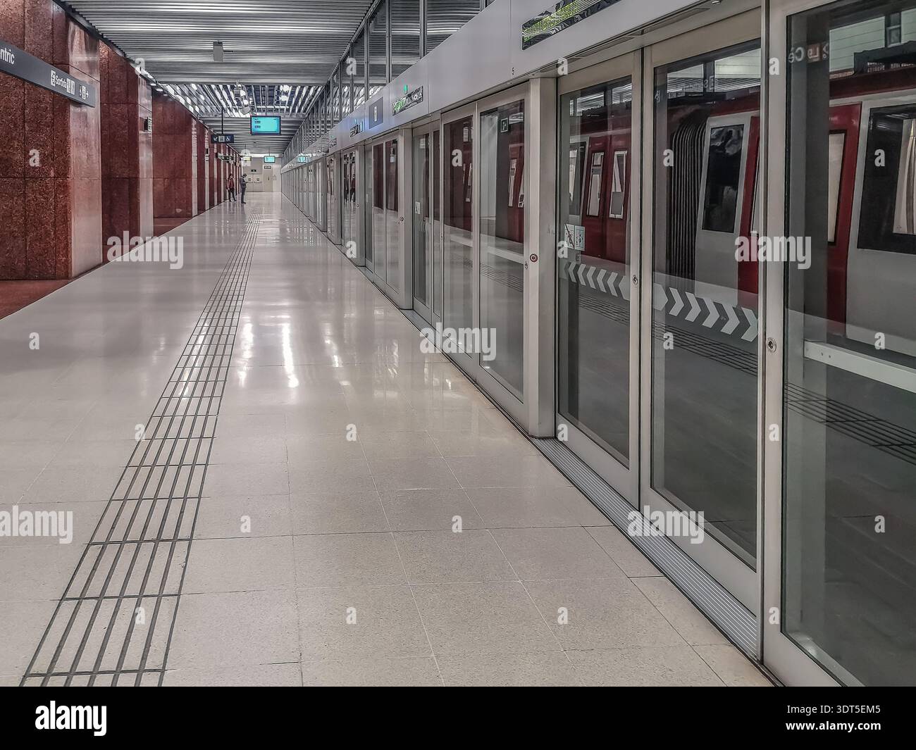 Barcelona, Spain - November 26, 2021: Interior of Zona Universitaria metro station in Barcelona in perspective. Modern long tunnel with glass entrance - Smartphone Captured Stock Image
