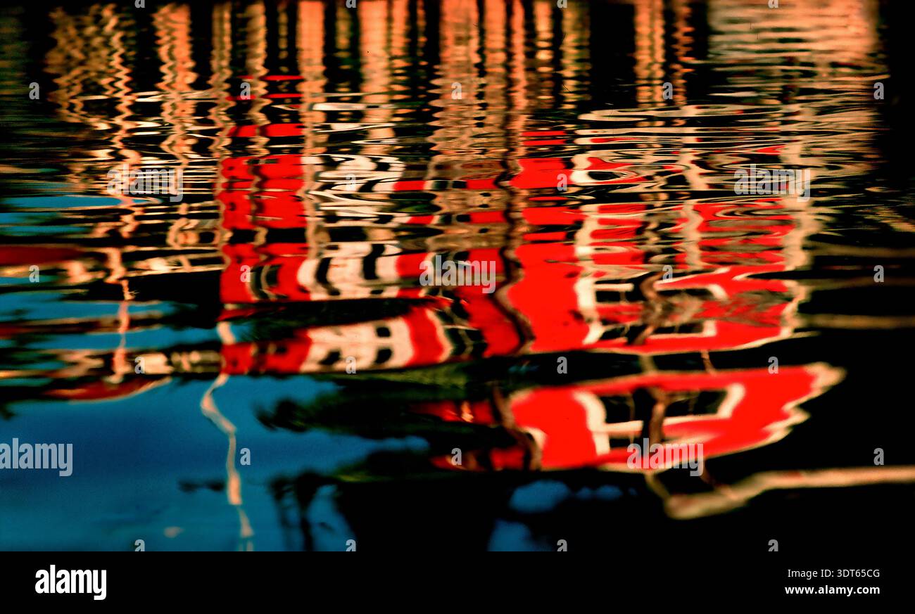 Water reflects the vibrant early evening colors of a fishing pier in Maine, USA Stock Photo