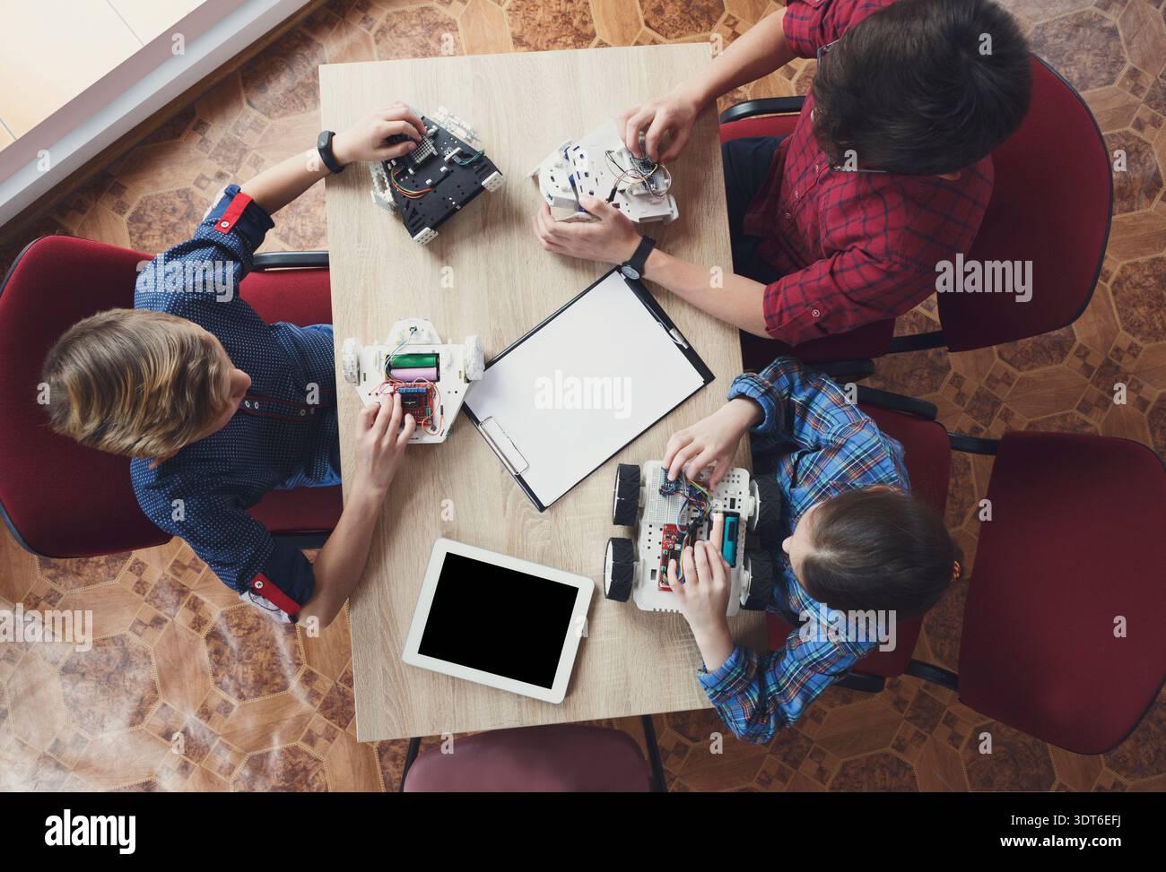 Students Working on Robotics Projects at a Table During an Educational Session Stock Photo