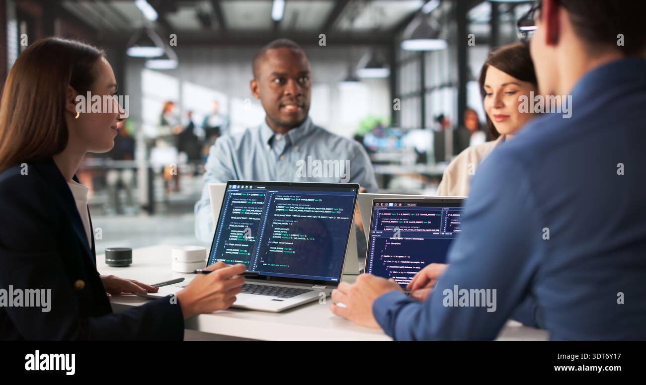 Diverse Group Of Engineers Collaborating On Software Development In Office. Stock Photo