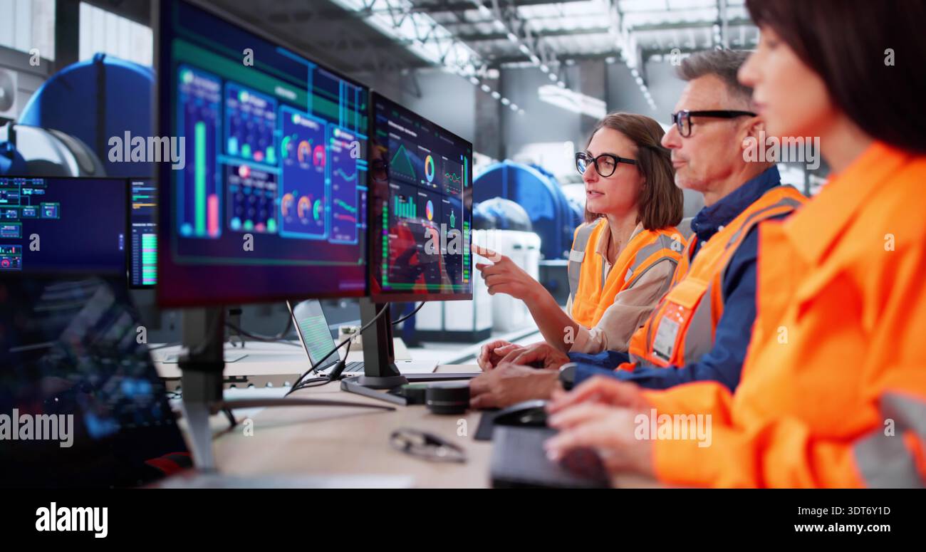 Engineers And Operator Meet In Modern Control Room For Maintenance Stock Photo