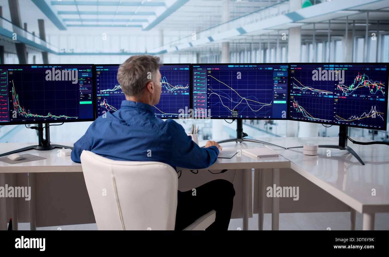 Senior Broker Analyzing Stock Market Data On Multiple Computer Screens Stock Photo