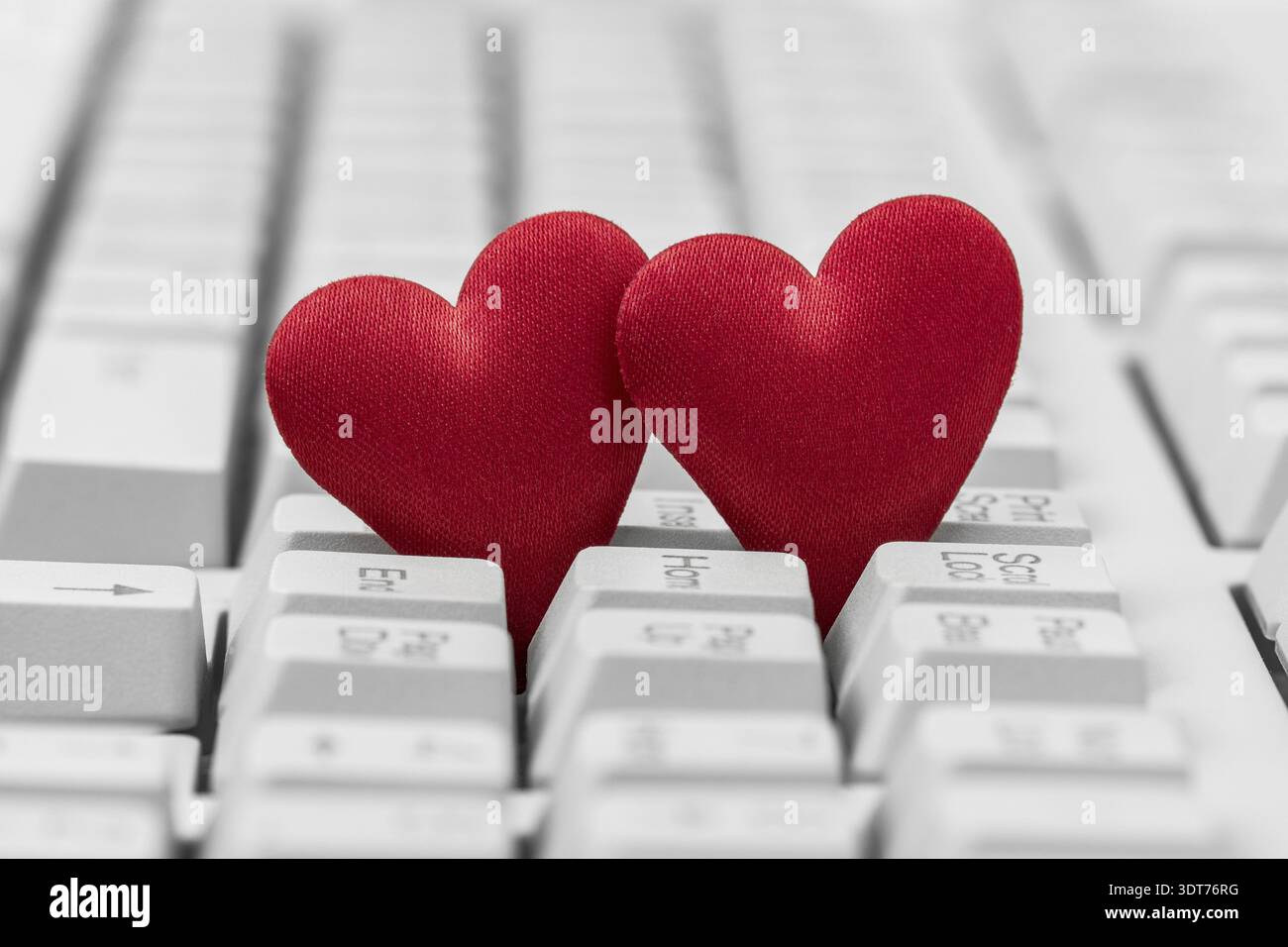 Small red hearts on keyboard. Internet dating concept Stock Photo