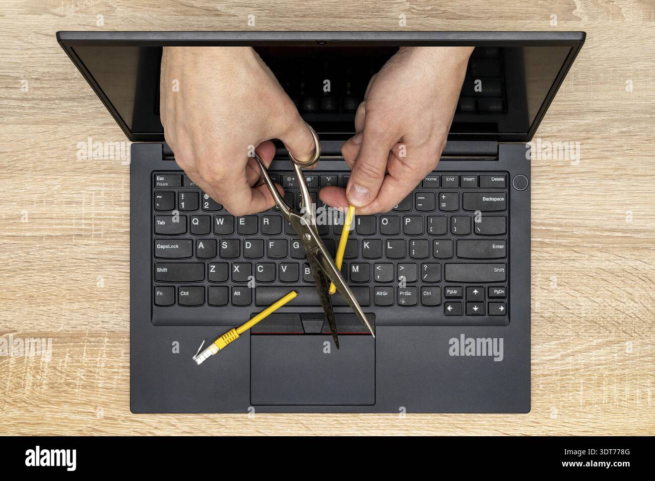 Network restrictions or censorship concept. Internet censor cutting a yellow network cable Stock Photo