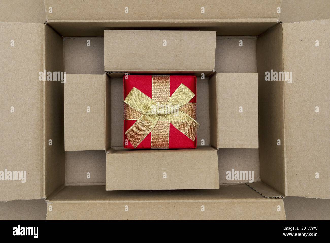 Opened large cadboard box with red gift box inside Stock Photo