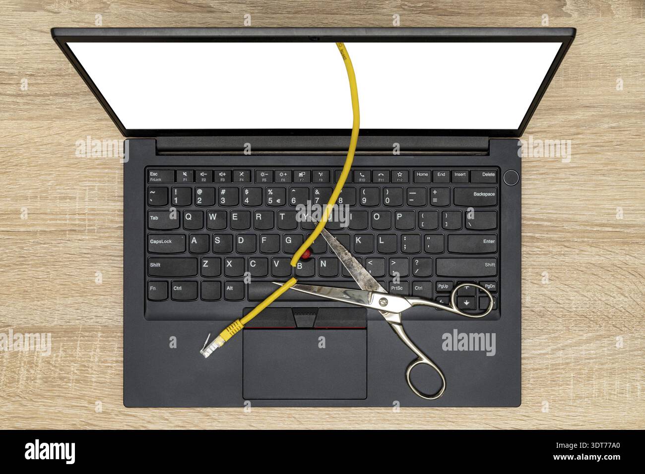 Network restrictions concept with laptop, scissors and cut cable Stock Photo