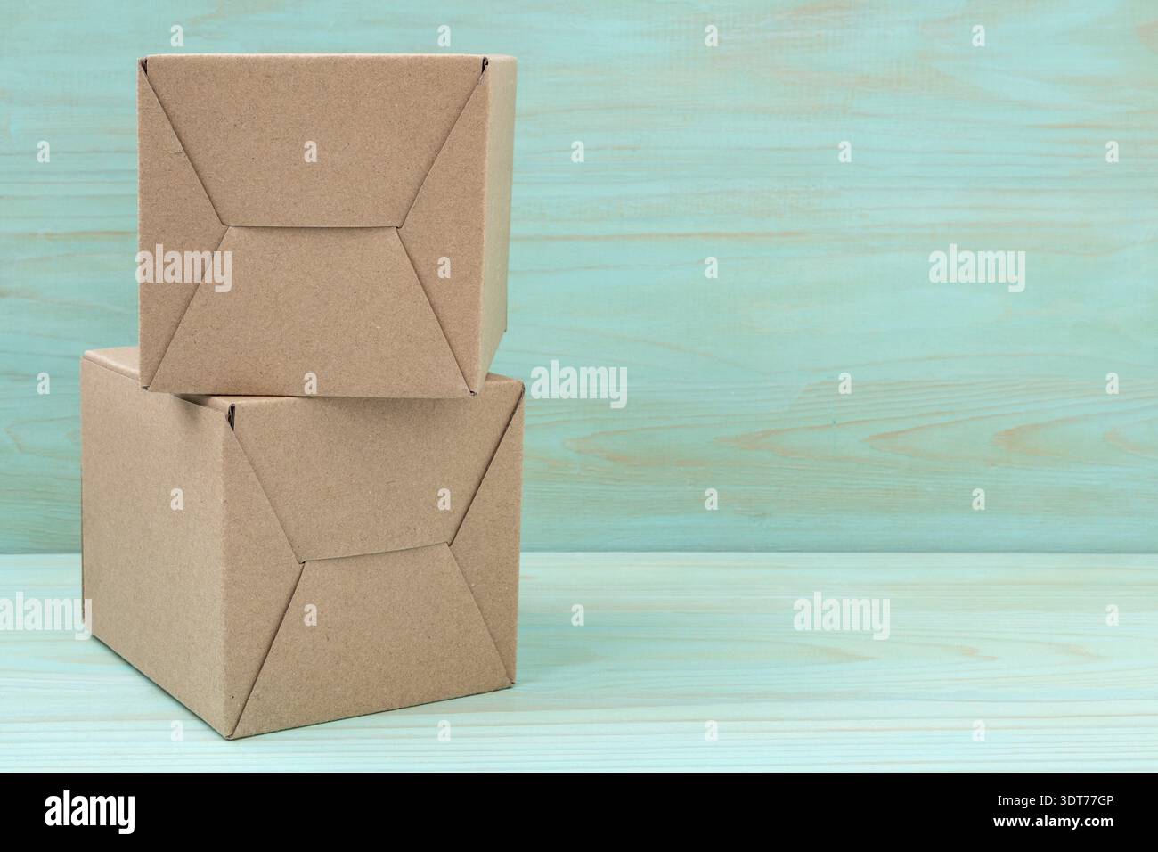 Stack of cardboard boxes on blue wooden background. Copy space Stock Photo