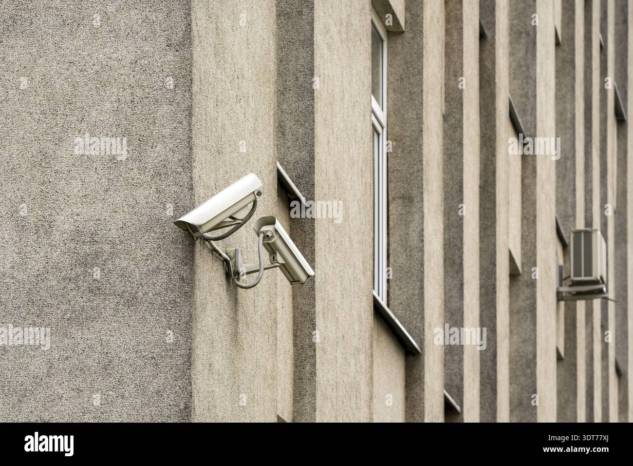 Two CCTV cameras on grey building wall. CCTV security system Stock Photo