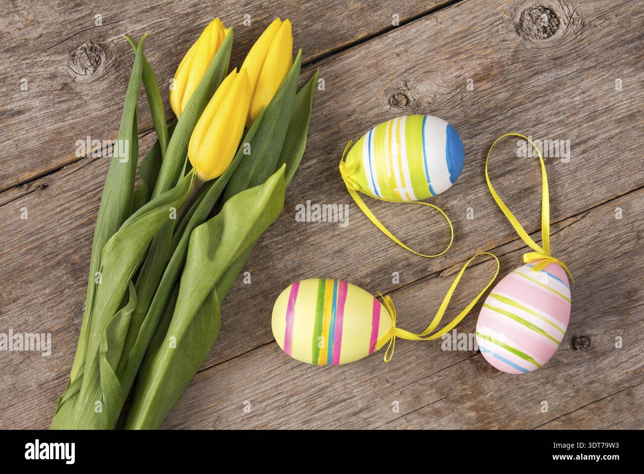 Three yellow tulips and three Easter eggs Stock Photo
