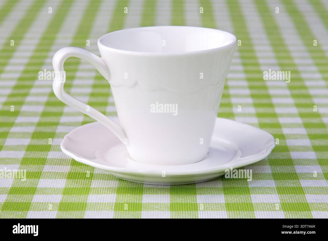 Empty cup on the checkered tablecloth texture Stock Photo