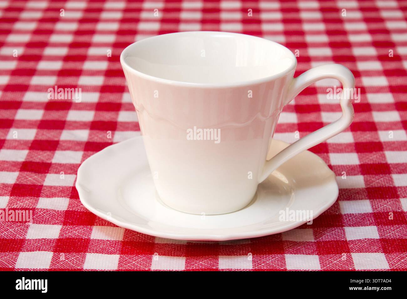 White cup on the checkered tablecloth texture Stock Photo