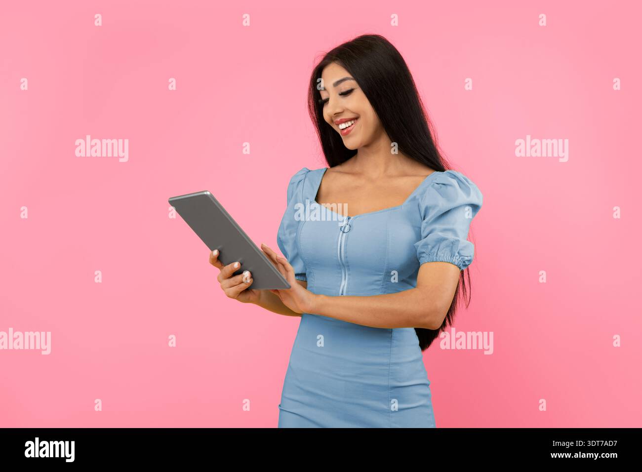 Cheerful young woman using tablet at studio Stock Photo