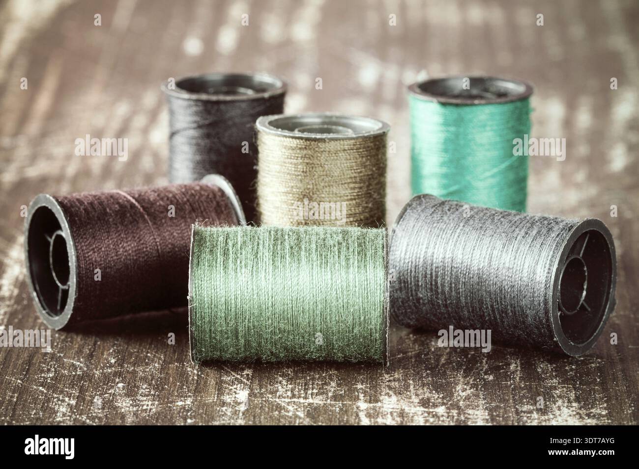 Bobbins with colorful threads on wooden background Stock Photo