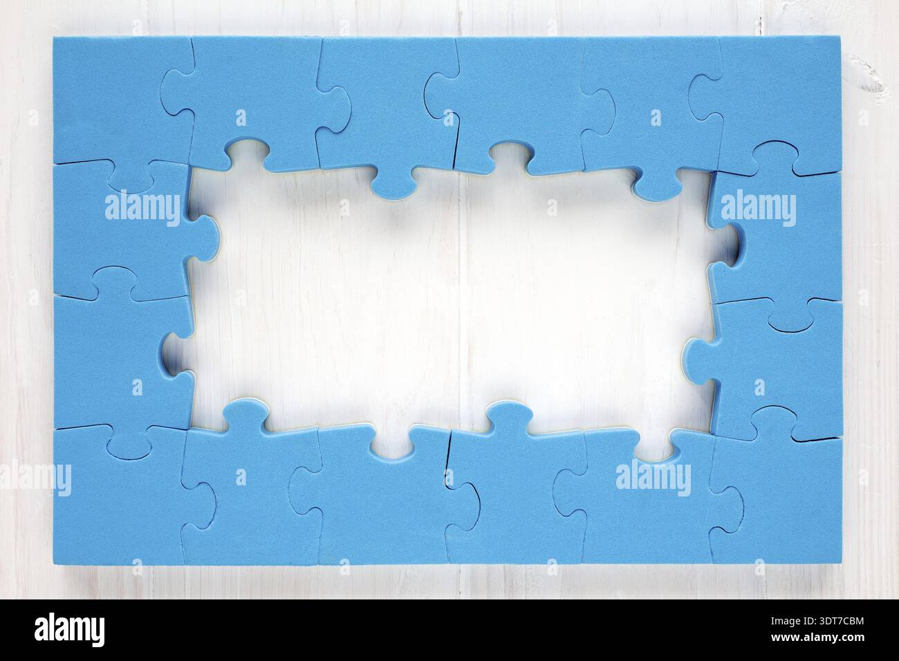 Blue puzzle frame on white wooden background Stock Photo
