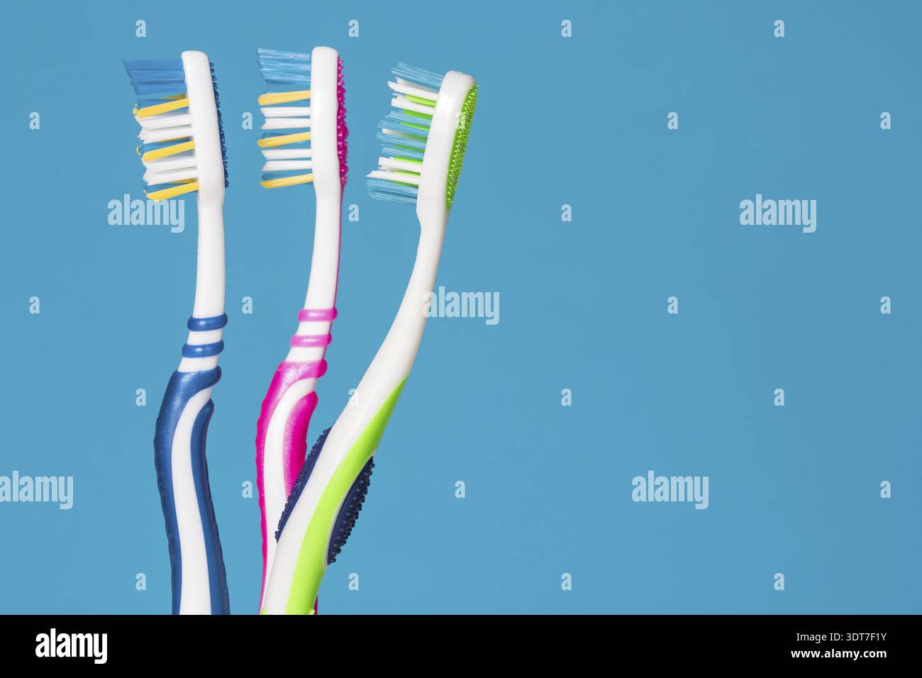 Three tooth brushes on the blue background Stock Photo