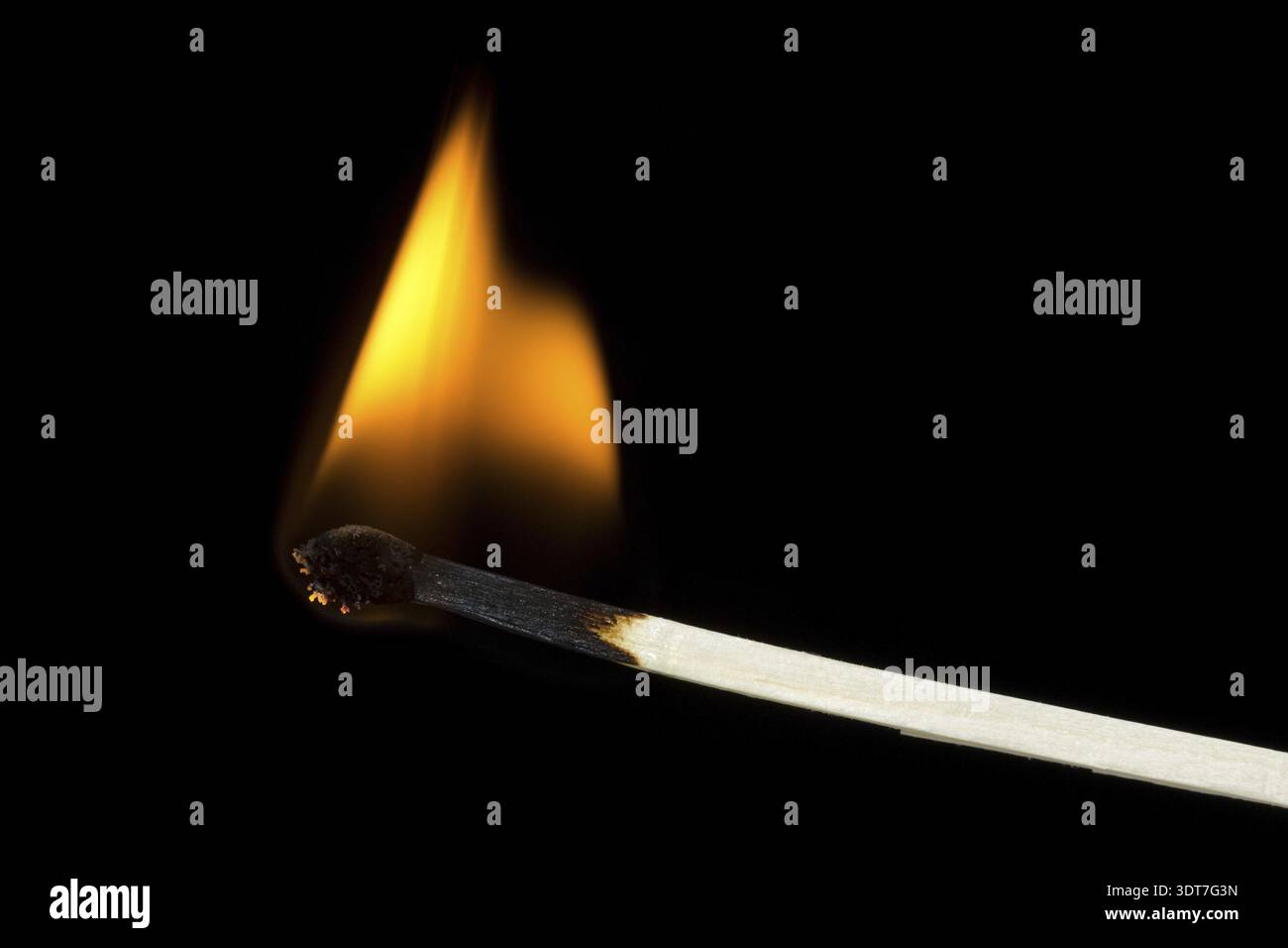 Burning flame on a matchstick over a black background Stock Photo