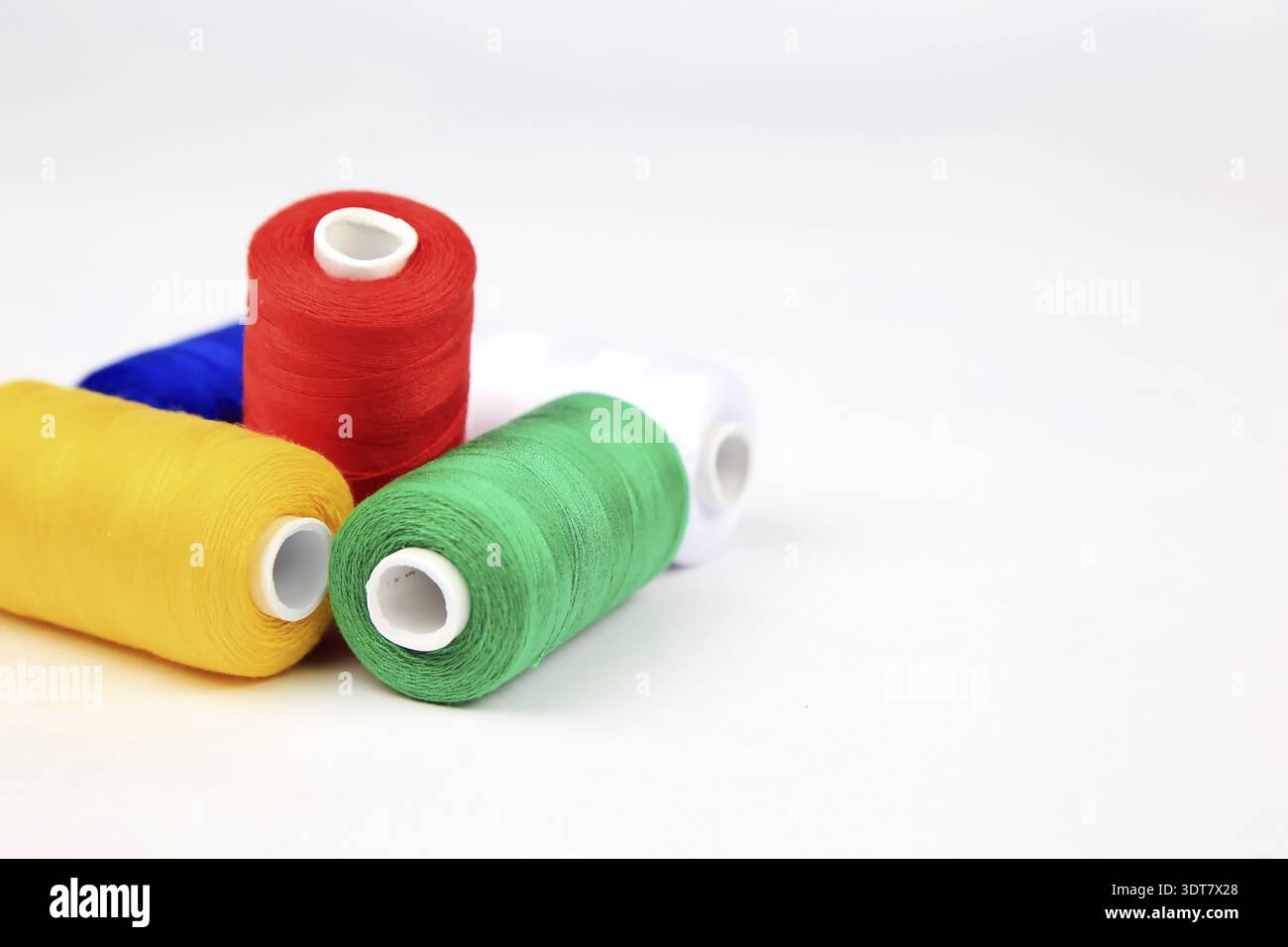 Colourful spools of thread lie on a white background Stock Photo