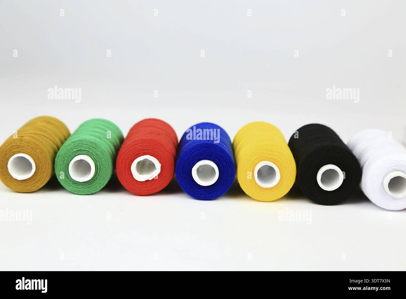 Several coloured spools of thread strung Stock Photo