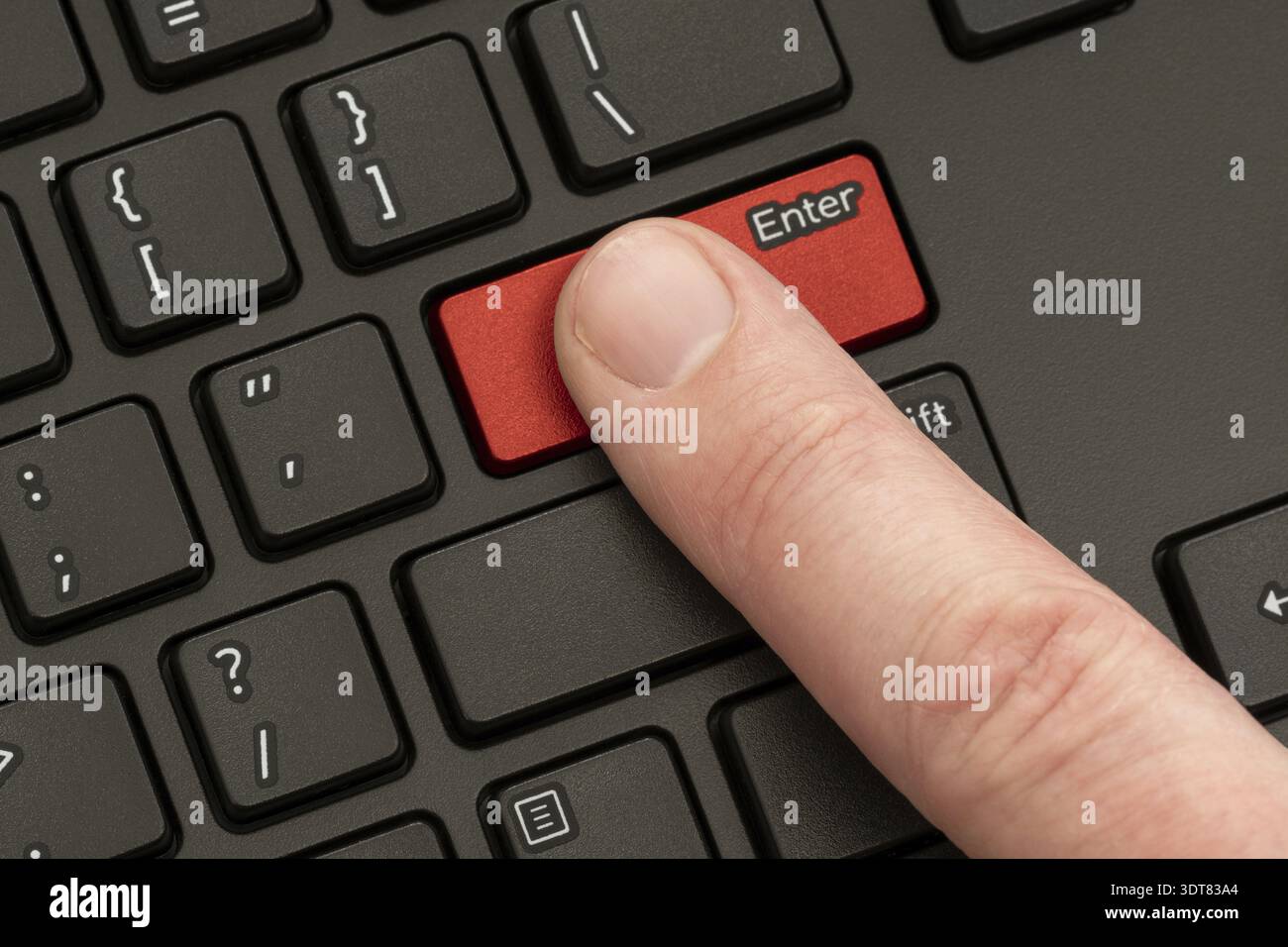 Finger pressing the ENTER button of computer keyboard Stock Photo