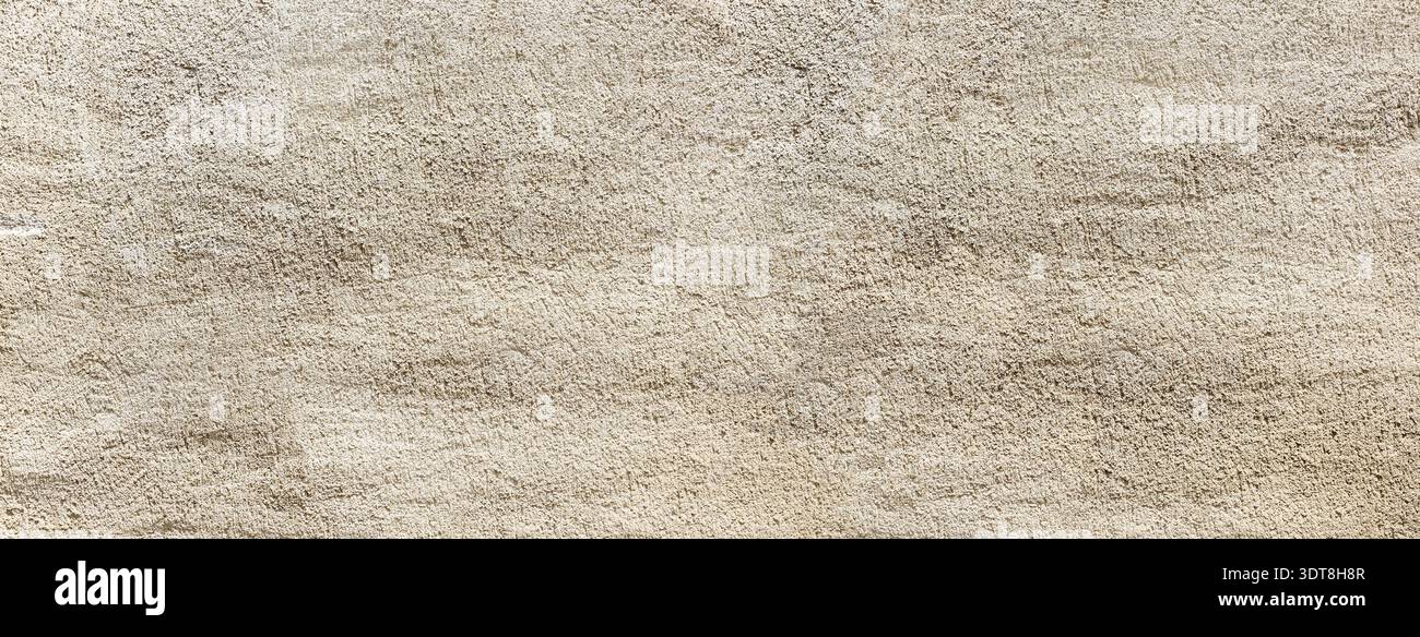 Rough beige plaster wall creating a grainy texture and layered background Stock Photo