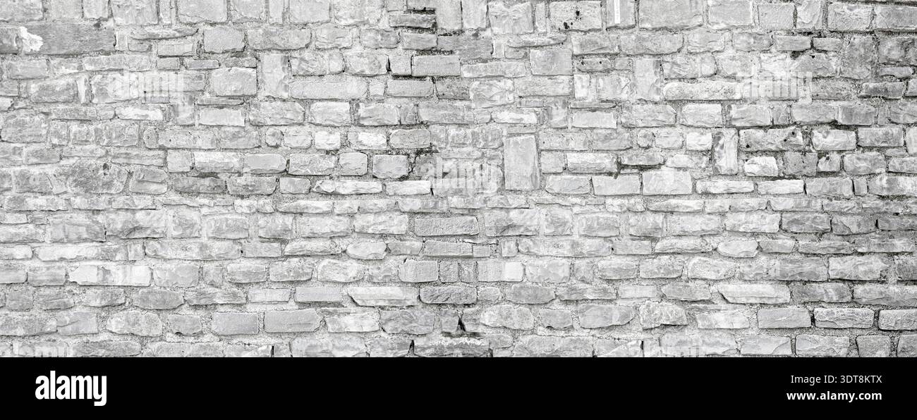 Weathered gray brick wall presenting a rustic old architectural background Stock Photo