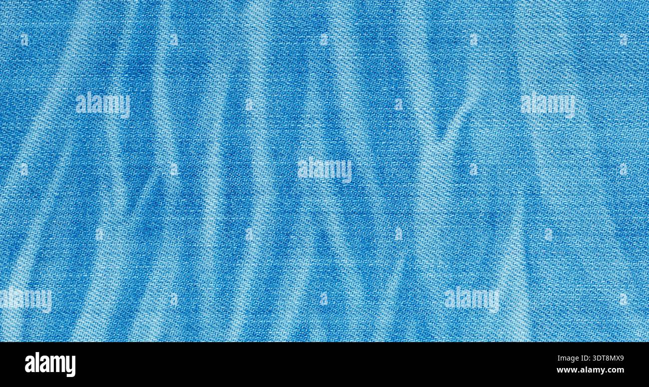 Faded blue denim fabric showing textile texture with light and dark patterns Stock Photo
