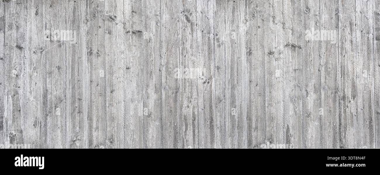Gray concrete wall displaying a weathered wood grain texture forming an industrial background Stock Photo