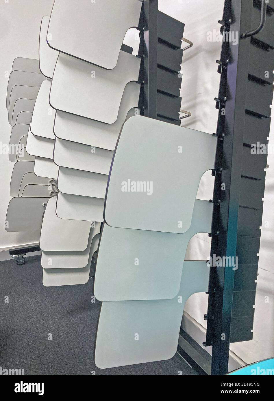View of f removable, desk-tops, designed to fix to chairs, in a storage racks, in a University lecture Room. - Smartphone Captured Stock Image