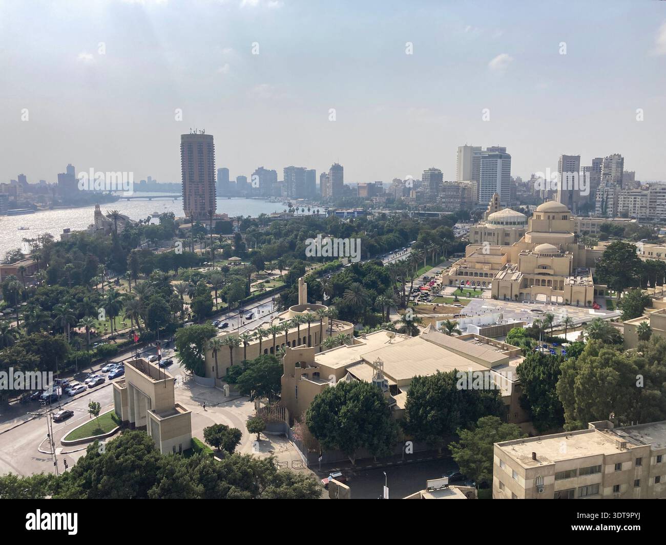 A roof-top view over central Cairo, Egypt with the Opera complex in the foreground and the circular tower of the Sofitel hotel on the Nile river bank. - Smartphone Captured Stock Image