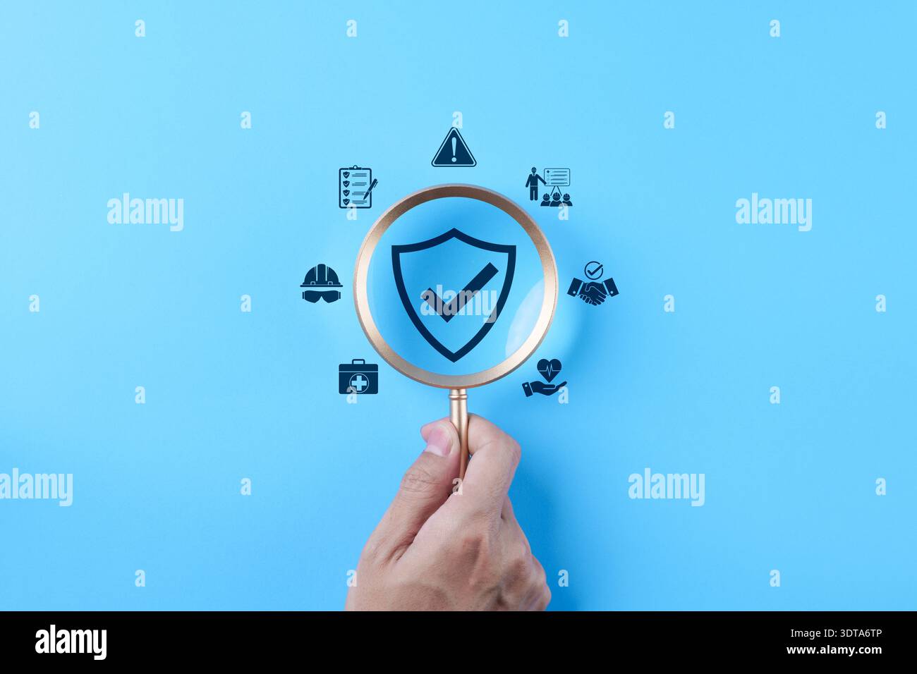 Work safety concept. hand holding magnifying glass over shield check ...