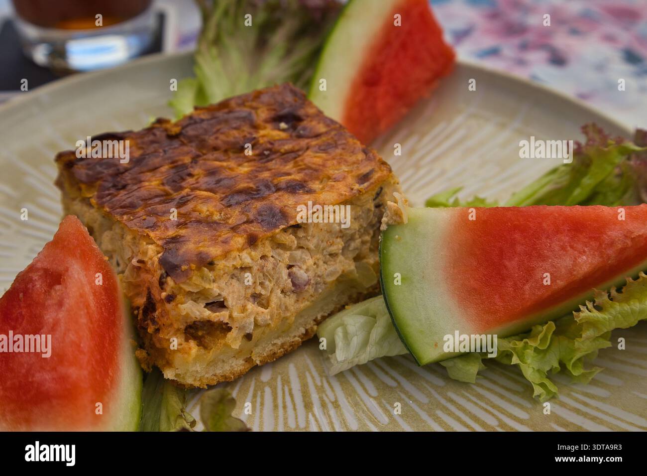 Hausgemachter Zwiebelkuchen: Regionale Spezialität im Restaurant Weinkeller Wallendorf, serviert mit Wassermelone & Salat, Schkopau, Sachsen-Anhalt Stock Photo