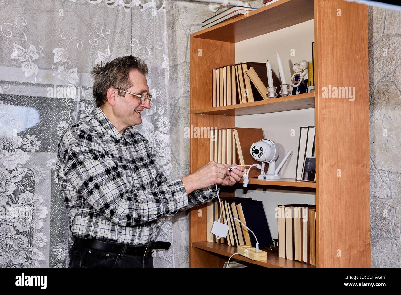 Elderly farmer tests new surveillance camera. Stock Photo