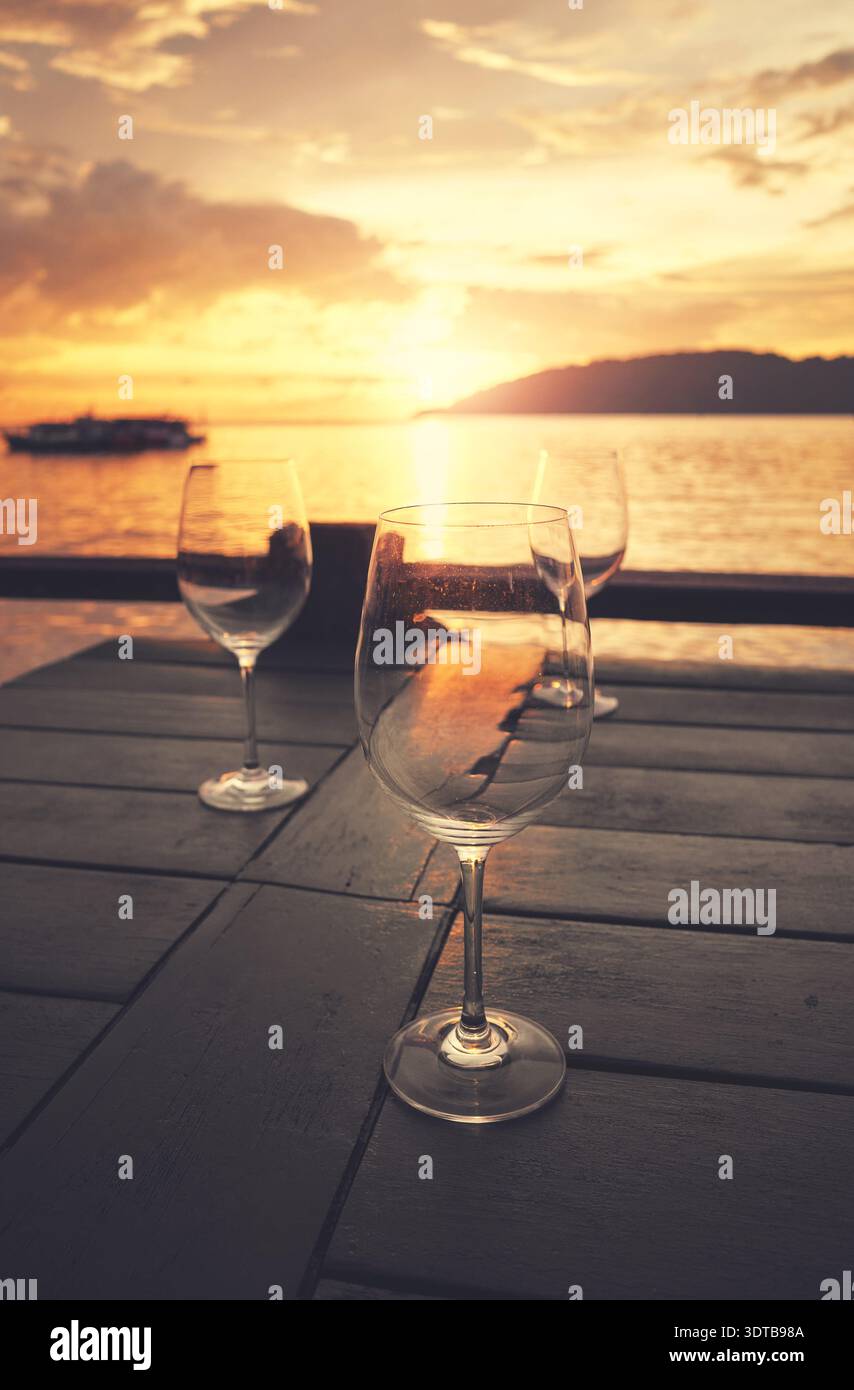 Empty wine glasses placed on a table at sunset, selective focus. Stock Photo