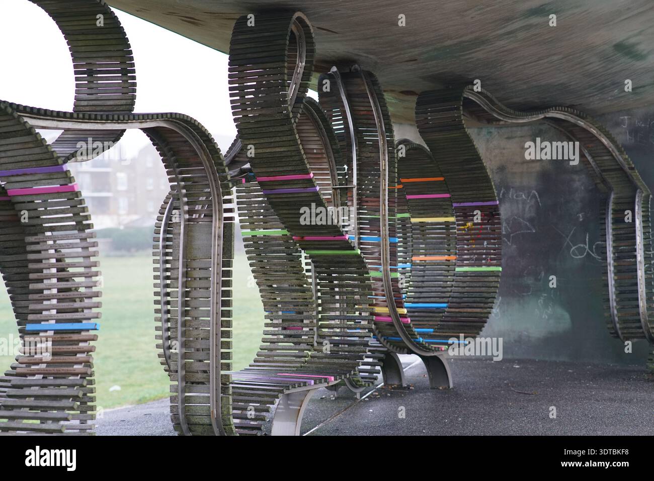 Underside of The Long Bench sculpture in Littlehampton, colourful striped metal ribbons and curves, East Beach public art, West Sussex England. Stock Photo