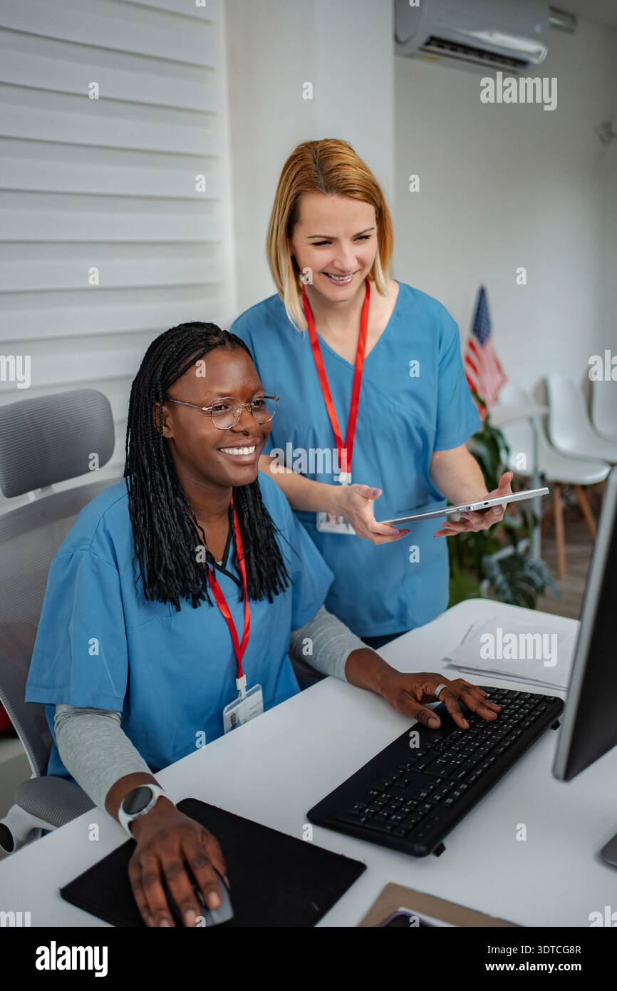 Healthcare professionals collaborating on computer using digital tablet Stock Photo