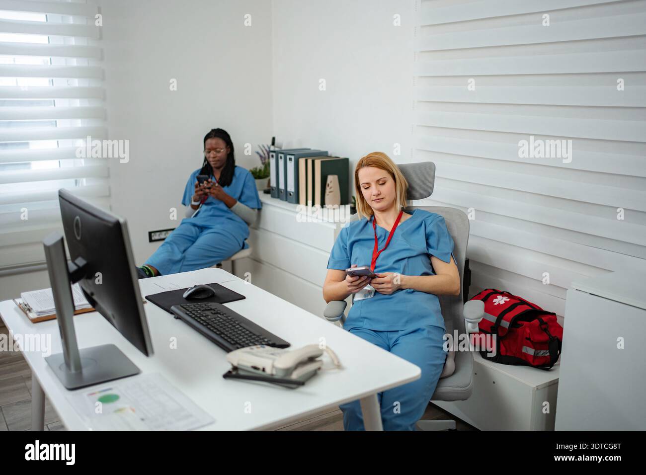 Healthcare workers taking a break using smartphones Stock Photo